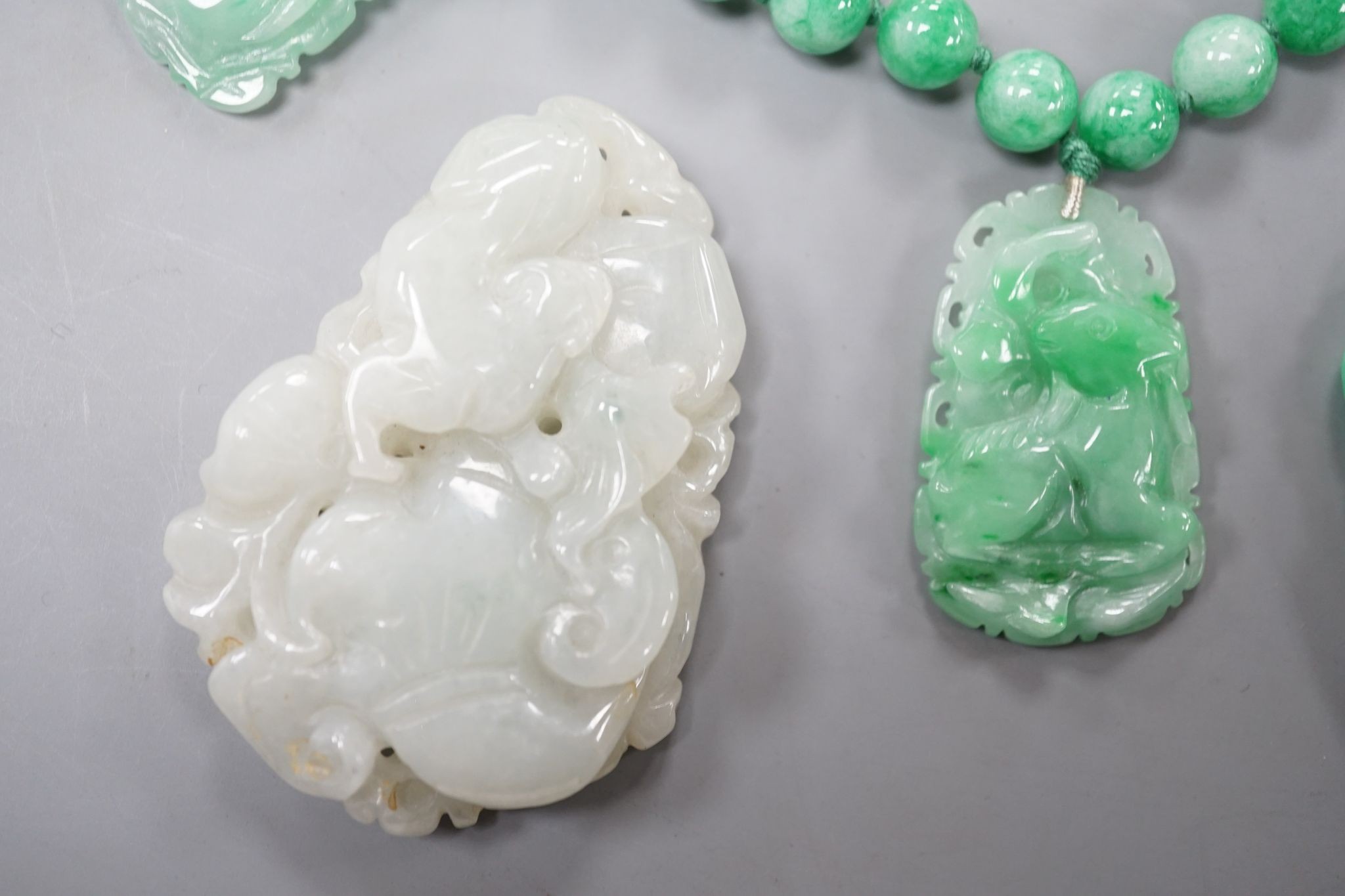 A jade bead necklace hung with three jade carvings, 49cm and three other jade carvings.